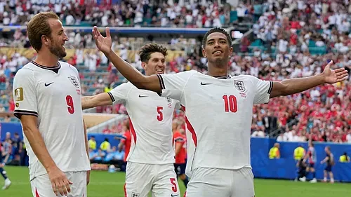 Jude Bellingham ha vuelto a vestirse de héroe nacional en una noche que ya forma parte de la historia del fútbol británico. El centrocampista del Real Madrid, en un estado de gracia absoluto, ha catapultado a la selección de Inglaterra a las semifinales del Mundial tras vencer por 2-1 a una rocosa Noruega en el tiempo extra. Bajo el sofocante calor de Miami, donde las temperaturas alcanzaron los 33 grados, el joven astro firmó un doblete decisivo que permite a los de Thomas Tuchel seguir en la pelea por la Copa del Mundo. El encuentro comenzó con un ritmo lento, descrito por las crónicas como una «primera hora de siesta en Miami», donde el conjunto de Solbakken supo cerrar espacios con éxito. Noruega sorprendió al abrir el marcador a los 36 minutos gracias a Andreas Schjelderup, quien anotó un «golazo» con un disparo que se coló por la escuadra tras golpear en el poste, silenciando a una grada donde se encontraban David Beckham y Mick Jagger. Sin embargo, antes del descanso, Bellingham asumió el destino de su país. El empate llegó tras una jugada rodeada de polémica: Noruega protestó que el balón había tocado un cable de la spider cam en el saque de puerta previo, pero la FIFA aseguró que la tecnología del balón no detectó impacto alguno. El madridista no desaprovechó la ocasión y batió a Nyland con un disparo raso. La segunda mitad estuvo marcada por la tensión y la intervención del videoarbitraje. Noruega llegó a celebrar el 2-1 tras un tanto de Heggem, pero el VAR advirtió un empujón de Erling Haaland sobre Anderson, invalidando el gol. El delantero del Manchester City, que se quedó sin marcar por primera vez en el torneo, acabó «abatido en el banquillo» tras ser sustituido en el tiempo extra. Fue en la prórroga cuando el oportunismo de Bellingham volvió a brillar. El centrocampista cazó un rechace del portero noruego para certificar el pase. Con este doblete, «Sir Jude» alcanza los seis goles en el torneo, igualando a Harry Kane y situándose a solo dos de Kylian Mbappé y Leo Messi. A pesar de la clasificación, el seleccionador Thomas Tuchel se mostró inusualmente severo: «Nos hicimos la vida muy, muy difícil hoy». El técnico alemán añadió de forma tajante: «El resultado es fantástico. Estamos entre los últimos cuatro. Es increíble, pero no estoy contento con el rendimiento... en ningún sentido». Ante la crítica, Bellingham respondió con un lacónico «Bueno, lo que sea», prefiriendo destacar el esfuerzo físico de sus compañeros. «Es cuestión de personalidad y perseverancia», afirmó el jugador, subrayando que «incluso cuando las cosas no estaban saliendo bien, encontramos la manera de volver a ganar. Ya sean en 90 o 120, vamos a dejarlo todo». Inglaterra se enfrentará ahora a la vigente campeona, Argentina, el próximo miércoles en Atlanta por un puesto en la gran final.